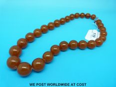 An amber necklace consisting of 29 graduated spherical beads, largest bead 2.5cm, smallest bead 1.