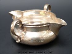 An Asprey hallmarked silver twin handled, twin beak jug, London 1916, length 10.