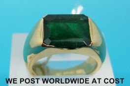 A gold ring set with an emerald cut emerald measuring approximately 3.