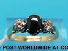 An 18ct gold ring set with an oval sapphire flanked by diamonds (size M)