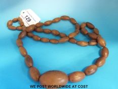 A rhinoceros horn necklace consisting of 46 oval graduated beads, the largest 35 x 23mm, 80cm long,