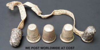 Five 19thC child's thimbles including a white metal pair joined by woven ribbon, 1.