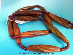 A rhinoceros horn necklace consisting of 12 carved elongated rhino horn beads with twisted