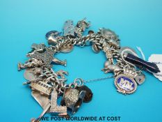 A large silver charm bracelet with various charms to include lapis lazuli, malachite,