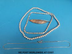 Two silver necklaces one with spherical beads and a silver leaf brooch