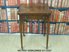 A rosewood quarter folding games table with gilt leather and felt top and line inlaid decoration
