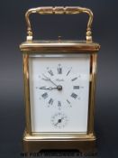 A brass repeater carriage clock striking on a gong.