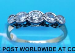 A yellow metal ring marked 18ct set with five old cut diamonds in a platinum setting,
