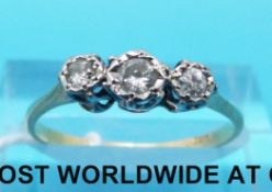 A yellow metal ring marked 18ct gold set with three round brilliant cut diamonds (size M)