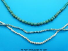 A necklace made up of spherical turquoise beads with silver clasp and two long necklaces made up of