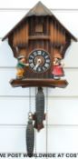 A German black forest cuckoo clock featuring a boy and girl figure