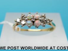 An 18ct gold ring set with four opals and six diamonds,