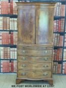 A reproduction serpentine-fronted cabinet on chest with mahogany brush slide raised on bracket feet