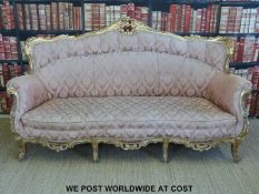 A 19thC gilt wood salon suite comprising an eight legged sofa and two chairs