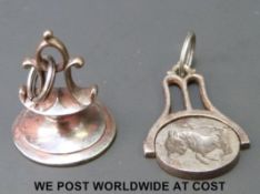 An 18thC cut steel armorial fob and a swivel fob of similar age with rearing bull to one side and