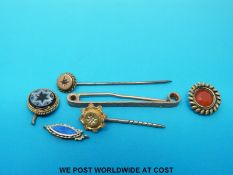 A 9ct gold stick pin set with a ruby, a 15ct gold stick pin set with a diamond,