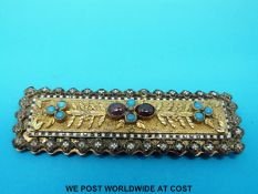 An unusual buckle set with an enamel border and turquoise and garnet cabochons