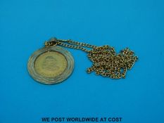 A gold one Rand coin in 9ct gold mount and with yellow metal chain marked 14ct (14.