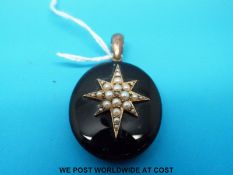 A Victorian pendant set with a diamond to the centre surrounded by seed pearls in a star shape