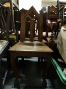 Two Victorian Gothic Revival oak hall chairs