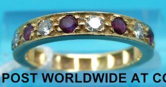 A yellow metal half eternity ring set with alternating diamonds and rubies (size J)