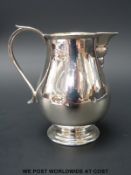 A George V hallmarked silver baluster shaped jug with gilt wash interior, Ldn 1914, height 8.