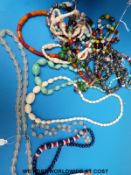 A quantity of beaded necklaces to include glass, ivory, wooden,