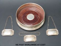 A feature hallmarked silver coaster and three hallmarked silver bottle tickets