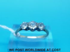 A yellow metal ring set with three old cut diamonds, the largest approximately 0.