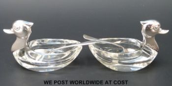 A pair of white metal and glass novelty salts formed as ducks, with 835 silver marks to necks,