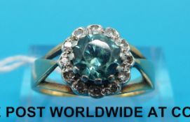 A yellow metal ring marked 18ct set with a round zircon surrounded by diamonds (size M)