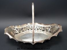 A George V hallmarked silver pierced swing handle basket, Sheffield 1911, length 31cm,