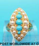 A Victorian/ Edwardian ring set with a graduating line of turquoise cabochons surrounded by