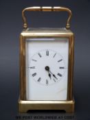A brass cased carriage clock with bevelled glass panels