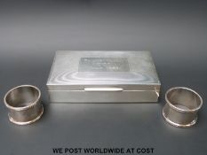 A hallmarked silver cigarette box (width 15cm) and two napkin rings (71g)