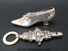 A hallmarked silver pin cushion shaped as a shoe together with a hallmarked baby's rattle