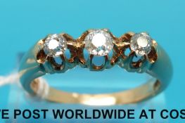 A yellow metal ring marked 18ct set with three old cut diamonds (size U)