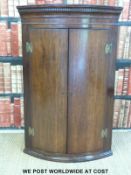 A 19thC bow-fronted mahogany hanging corner cupboard (H106 x W70 x D49cm)