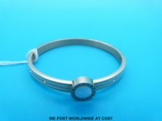 A bangle set with a mother of pearl disc,