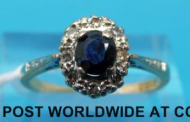 An 18ct gold ring set with sapphires and diamonds in an oval cluster (size N)