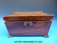 A 19thC two-division mahogany tea caddy raised on four brass feet