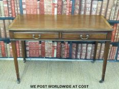 A mahogany two drawer desk or side table raised on tapering legs and brass castors (H74 x L114 x
