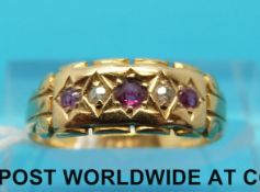 A yellow metal ring marked 18ct set with alternating diamonds and rubies (size K/L)