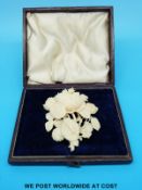 An ivory brooch formed as flowers in fitted case