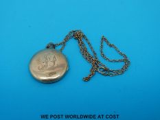 A yellow metal locket with chased foliate decoration to one side marked 15ct on a yellow metal