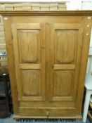 A pine two door wardrobe with shelves to one side and drawer below (W135 x D52 x H191)