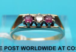 A 9ct gold ring set with a diamond flanked by a rubies