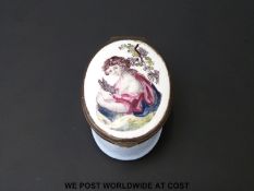 An 18thC Bilston enamel pill box decorated with a lady holding a rabbit underneath a vine, 2cm tall,