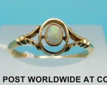 A yellow metal ring set with an oval opal cabochon,