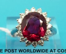An 18ct white gold ring set with a large synthetic ruby surrounded by diamonds (size R)